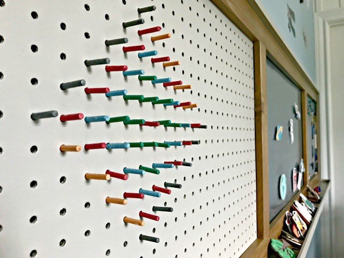 Colorful DIY pegs made from dowels in a painted pegboard. Build a fun DIY Modern Farmhouse Kids Activity Wall Board. With 20 Ideas for board options that work for kids, teens, and adults. #ModernFarmhouse #KidsFurniture #DIYKids #AbbottsAtHome