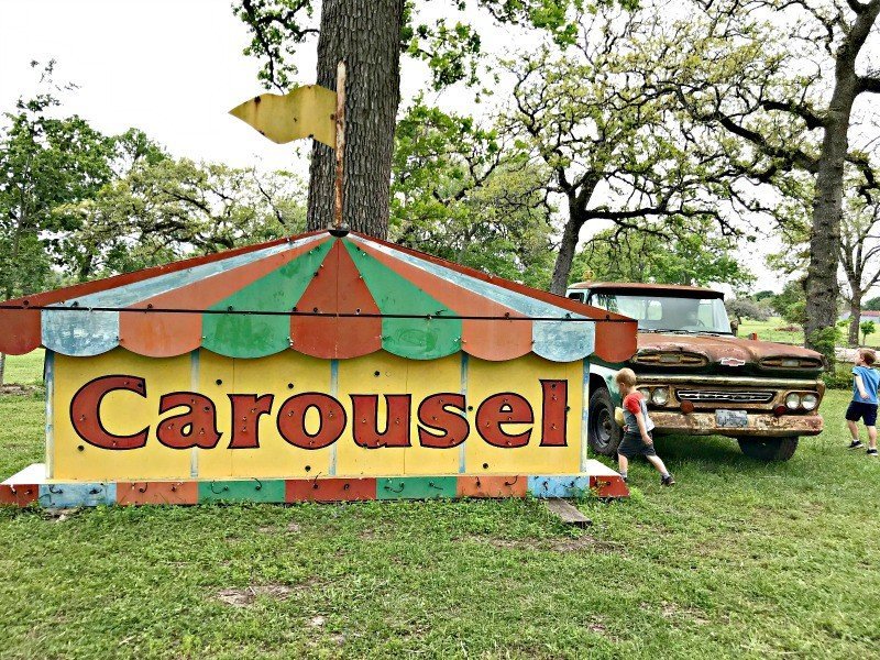 An old Carousel sign sits next to a rusty old truck outside the Junk Gypsy shop. A few more Round Top Shopping Trip Tips and some photos from the Junk Gypsy Headquarters. A shopping trip to Round Top and Waco would make a perfect weekend, guys! #AbbottsAtHome #RoundTopTexas #JunkGypsy #GirlsWeekend