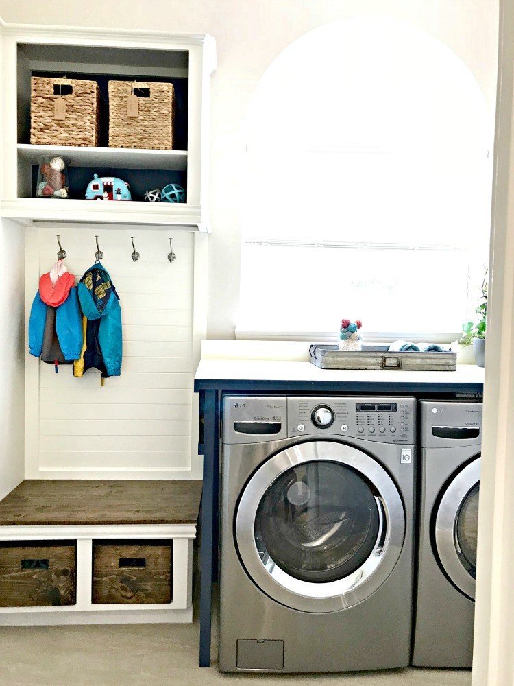 This mudroom bench and coat storage used to be a standard base cabinet and upper cabinet before she cut them in half. This Modern Farmhouse DIY Laundry Room Makeover Ideas post is full of Before & After Makeover Photos, budget-friendly DIY ideas, and Laundry Room decor. #LaundryRoom #BeforeandAfter #AbbottsAtHome