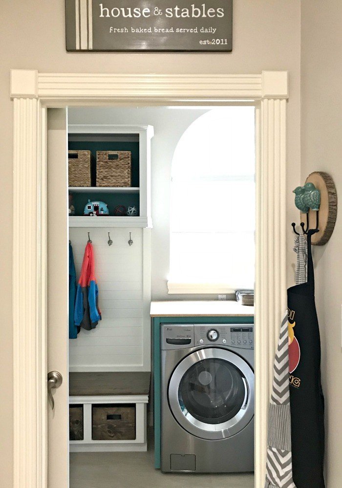 The DIY Mudroom Bench in a Modern Farmhouse look using teal, wood, and lots of white. This Modern Farmhouse Small Laundry Room Design is full of easy DIY projects and affordable decor. #LaundryRoom #ModernFarmhouse #Teal #AbbottsAtHome
