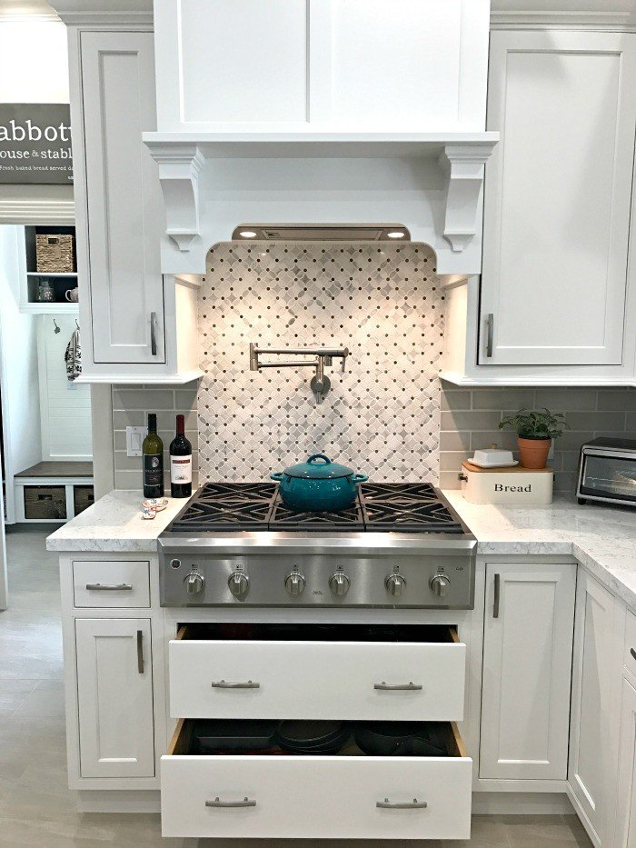 Kitchen Remodel Before and After Photos using White Cabinets, Stained Wood Island, and Marble Look Quartz Counters. Plus, how to change the layout and plan a kitchen remodel with good flow for your family before your remodel.  #AbbottsAtHome #KitchenRemodel #KitchenUpdate #KitchenMakeover #KitchenDesign #KitchenIdeas #WhiteKitchen