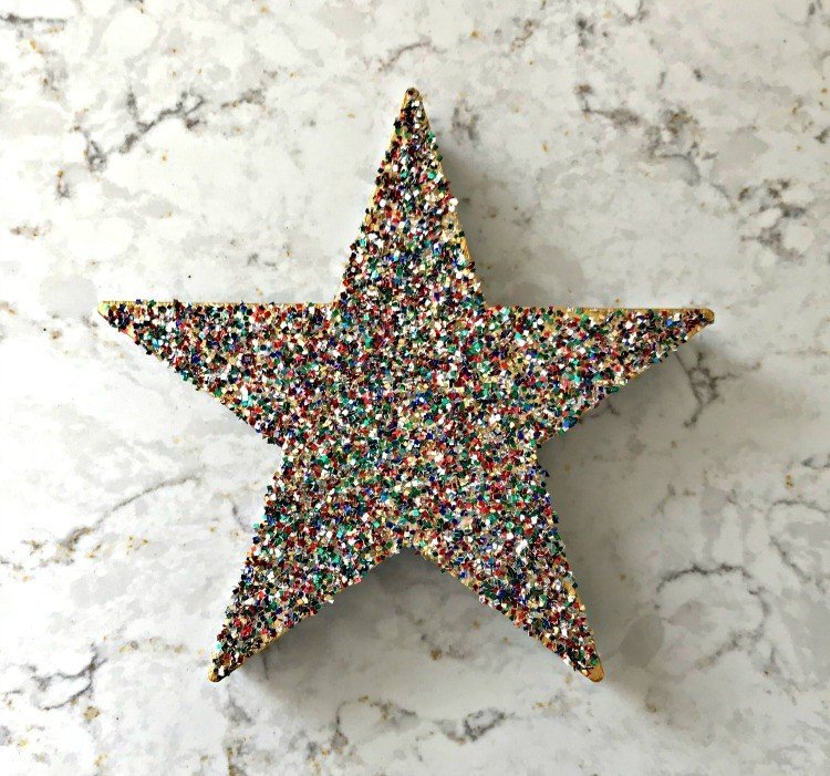 Glitter Star Ornament. Need some new ideas for this years Christmas craft? I've got 12 fun and easy handmade Christmas Ornament Ideas for you! Make 3D scrapbook paper trees, pom pom trees, star string art, unicorn stars, and more. #AbbottsAtHome #Handmade #ChristmasCrafts #ChristmasIdeas #ChristmasOrnaments