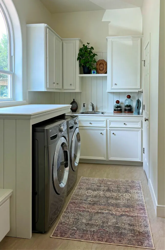 Image of a white laundry room mudroom combo with shiplap and a DIY laundry table over  the washer and dryer.
