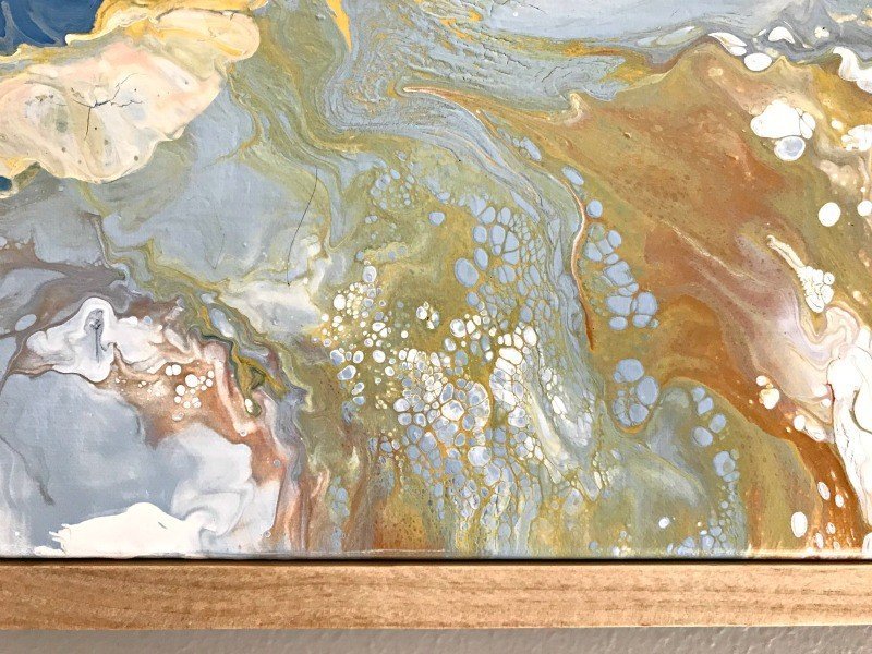 A close up of a DIY paint pour using acrylic paint. Click to see steps and how to video. #AbbottsAtHome #AcrylicPaint #AcrylicArt #Canvas #ArtIdeas #WallArt #DIYDecor #HandmadeArt