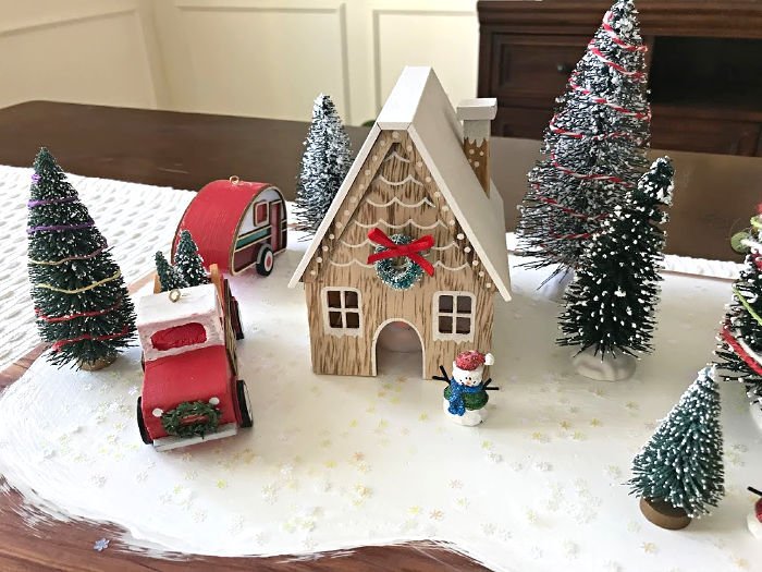 How to make this fun DIY Christmas Table Centerpiece with mini Christmas houses, bottle brush trees, and vintage red truck, camper, and car. DIY Red Truck Christmas Table Centerpiece. #AbbottsAtHome #CraftIdeas #CraftProjects #ChristmasProjects #ChristmasDIY