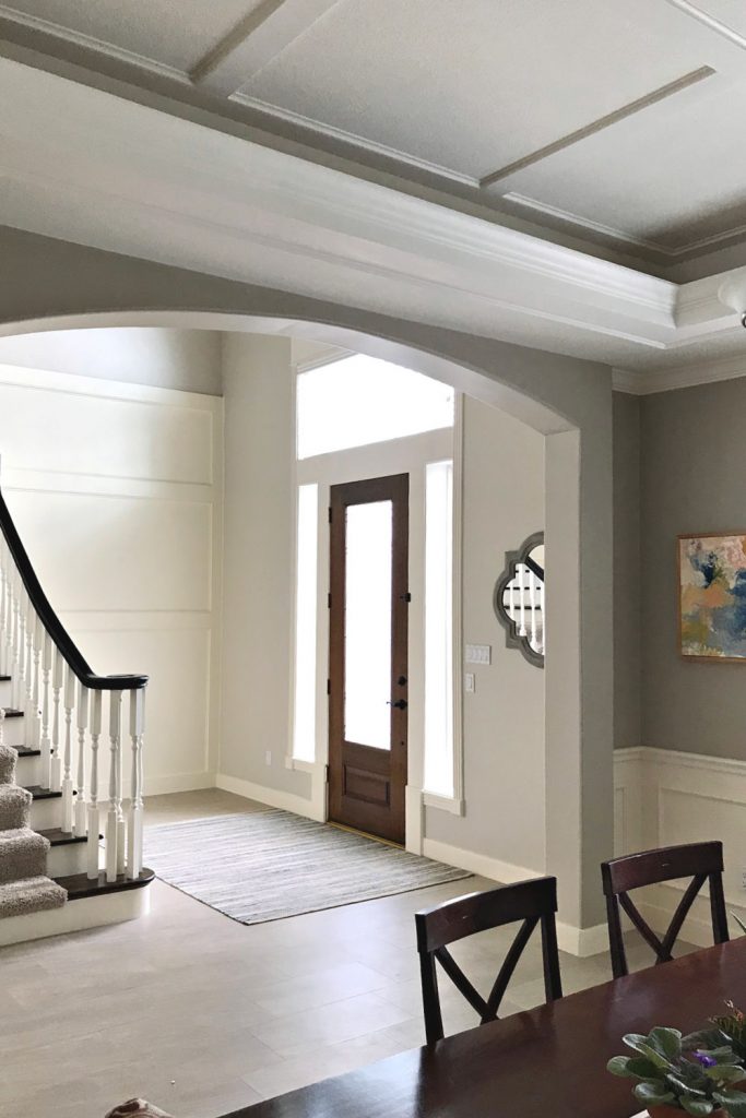 A white foyer with traditional stairs and with wood trim finish carpentry.