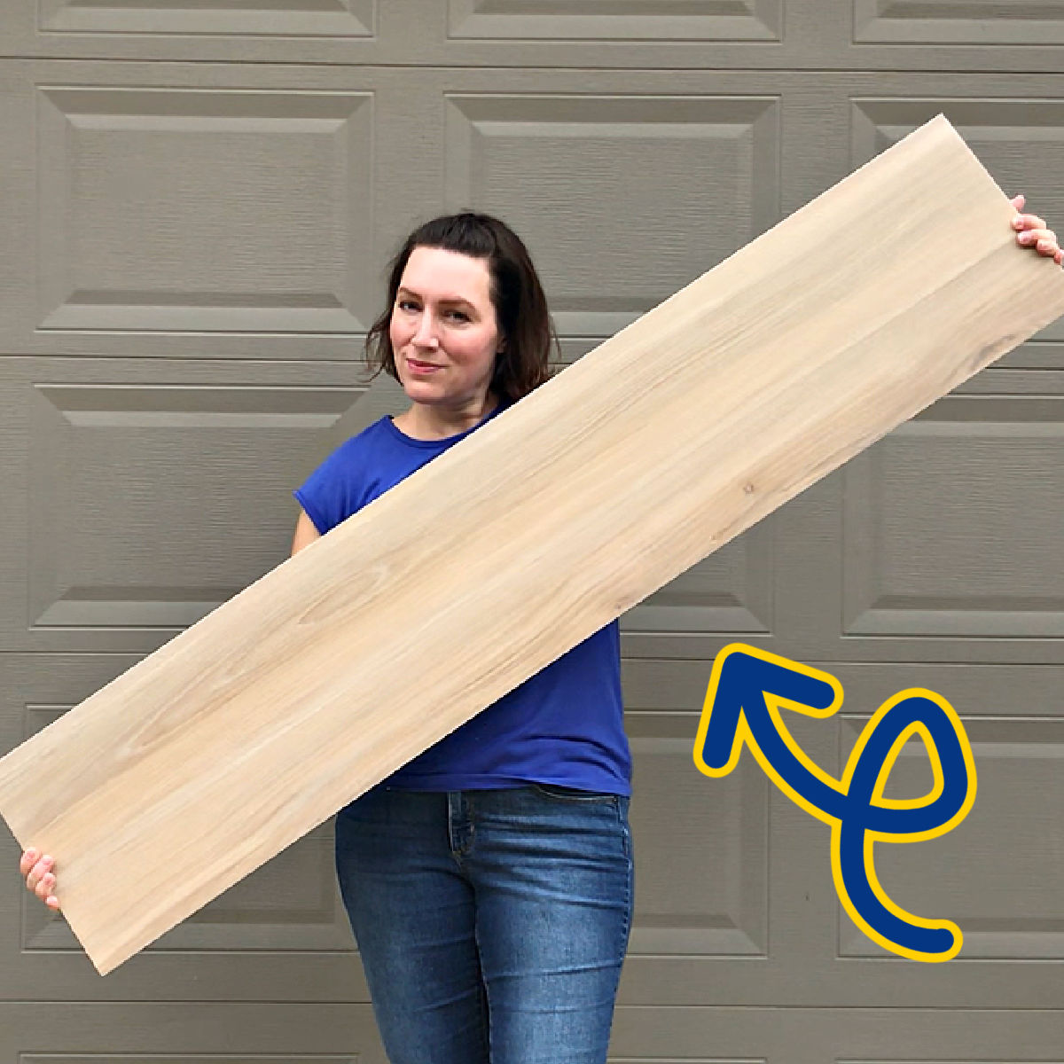 Image of an extra large wood look tile held by a woman, for a post about hoe bigger tiles are harder to install.