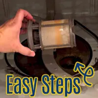 Image of someone cleaning a dishwasher filter for a post about How To Clean A Dishwasher & Dishwasher Filters Using Vinegar. With A Video Guide, Answers To Common Questions & Cleaning Tips!